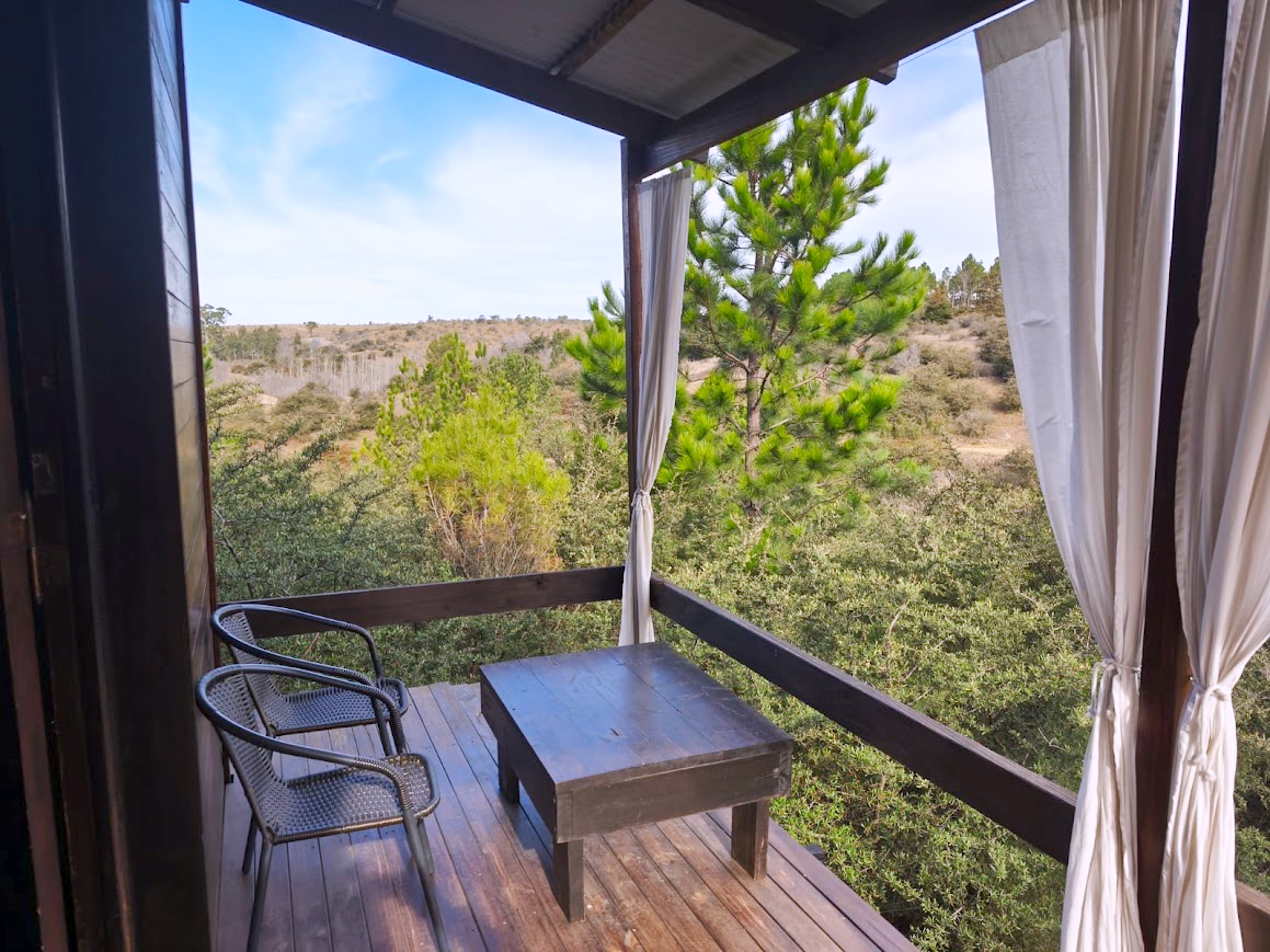 Galería de la Cabaña Chuña 1 con sillones y vista al monte serrano